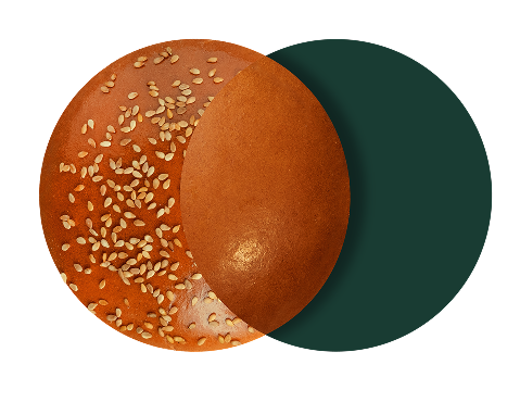 Un panino di sesamo con una metà marrone lucido e semi di sesamo, su sfondo scuro