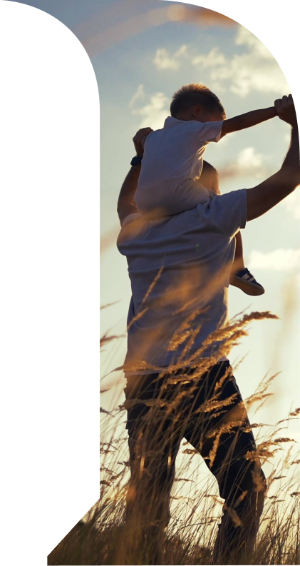 Padre che solleva il bambino durante il tramonto in un campo di grano