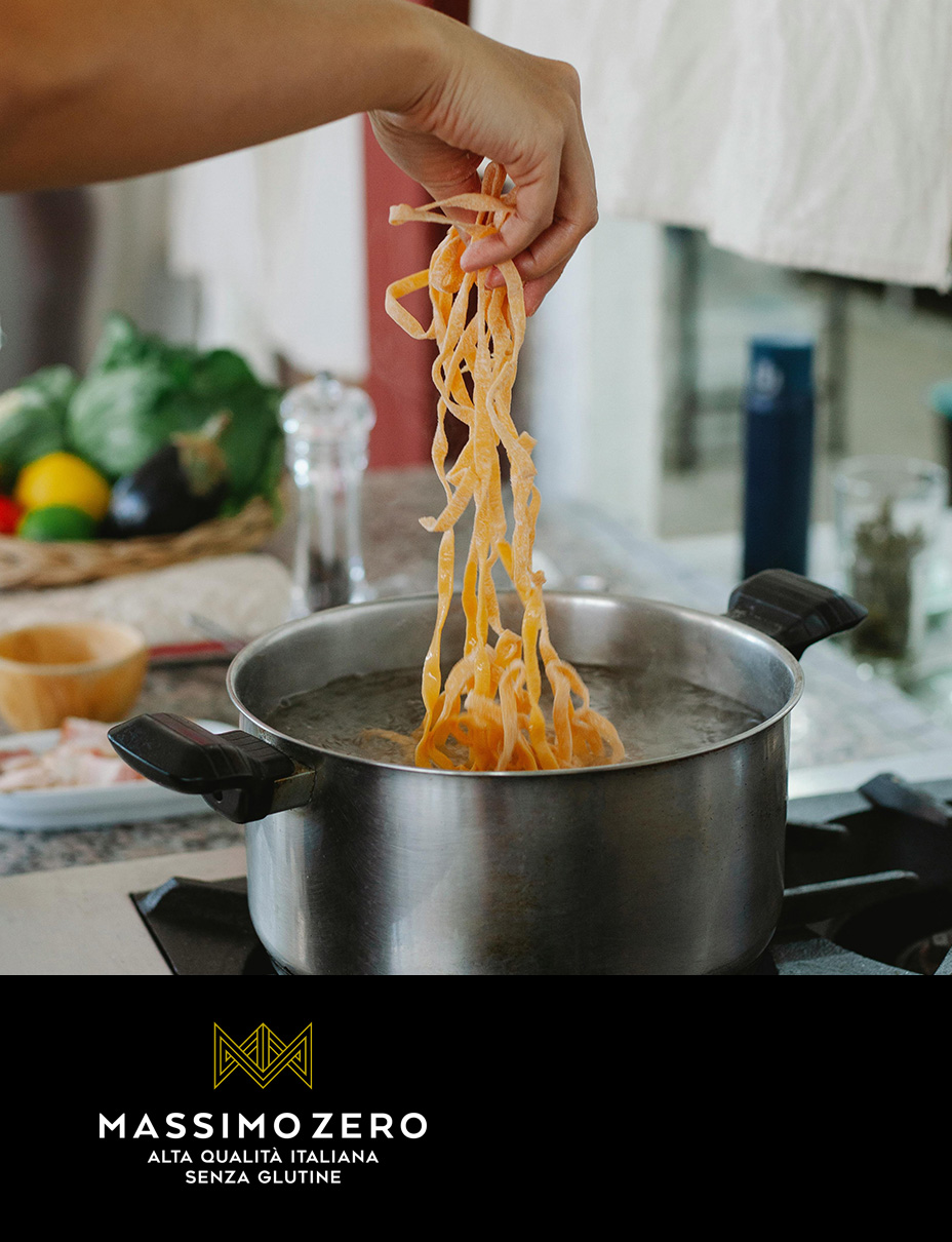 Uomo che solleva spaghetti cotti da una pentola, preparazione di un piatto di pasta