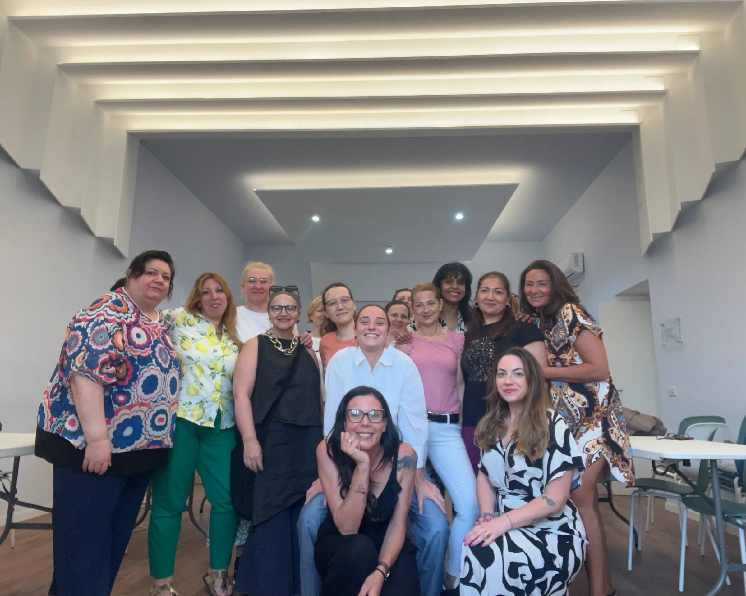 Gruppo di donne sorridenti in un ambiente luminoso e moderno durante un evento di networking