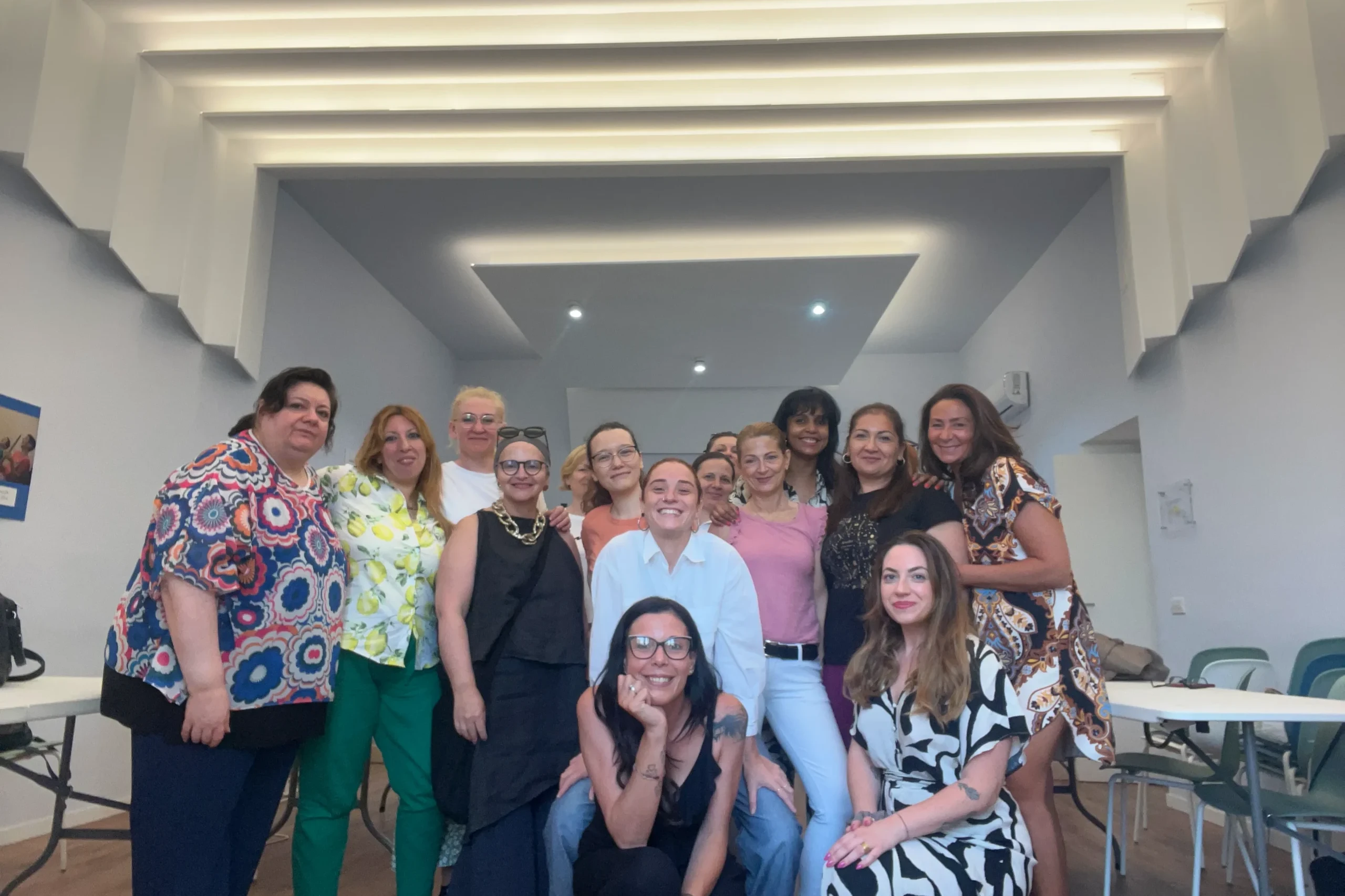 Gruppo di donne sorridenti in un ambiente luminoso e moderno durante un evento di networking